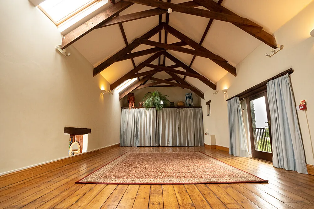 The meditation hall at Eden Rise near Totnes, a converted barn with exposed roof trusses